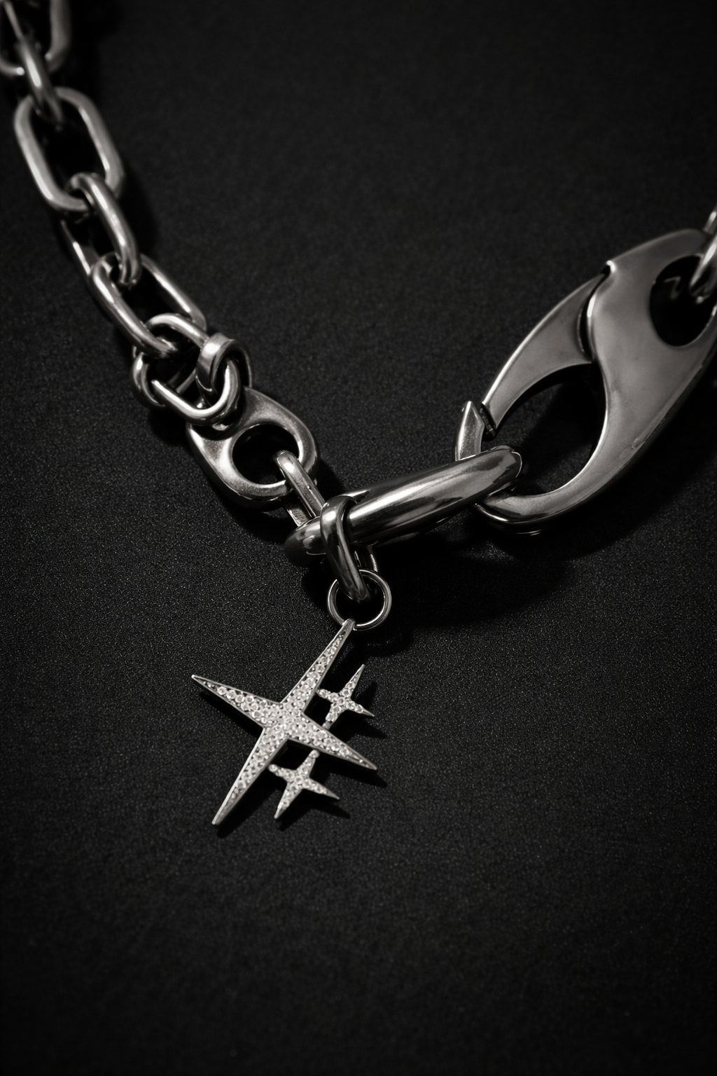 Near Earth Object | chain bracelet with a star-shaped charm on a black background
