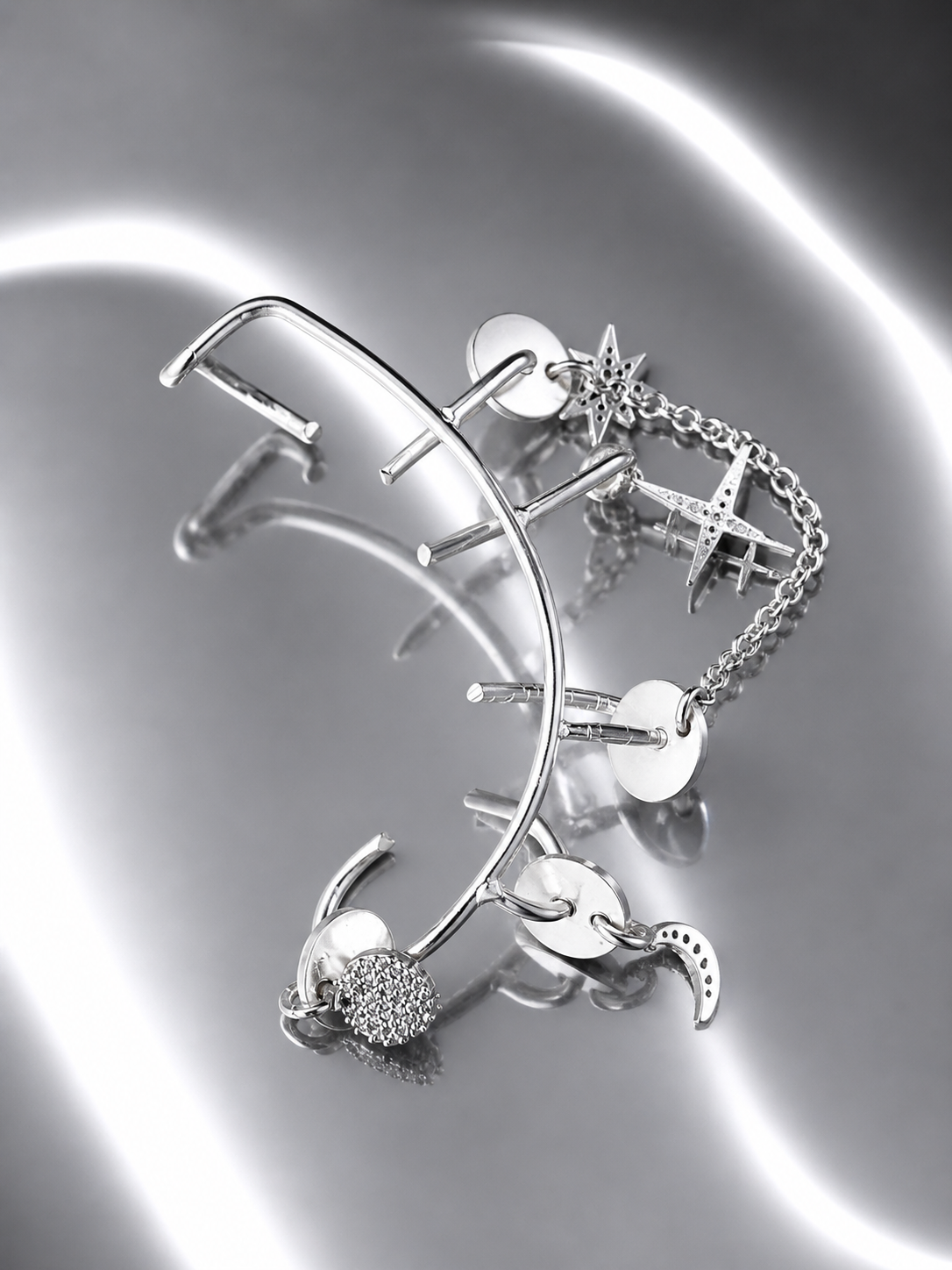 Near Earth Object | Silver earring and bracelet set on a reflective surface