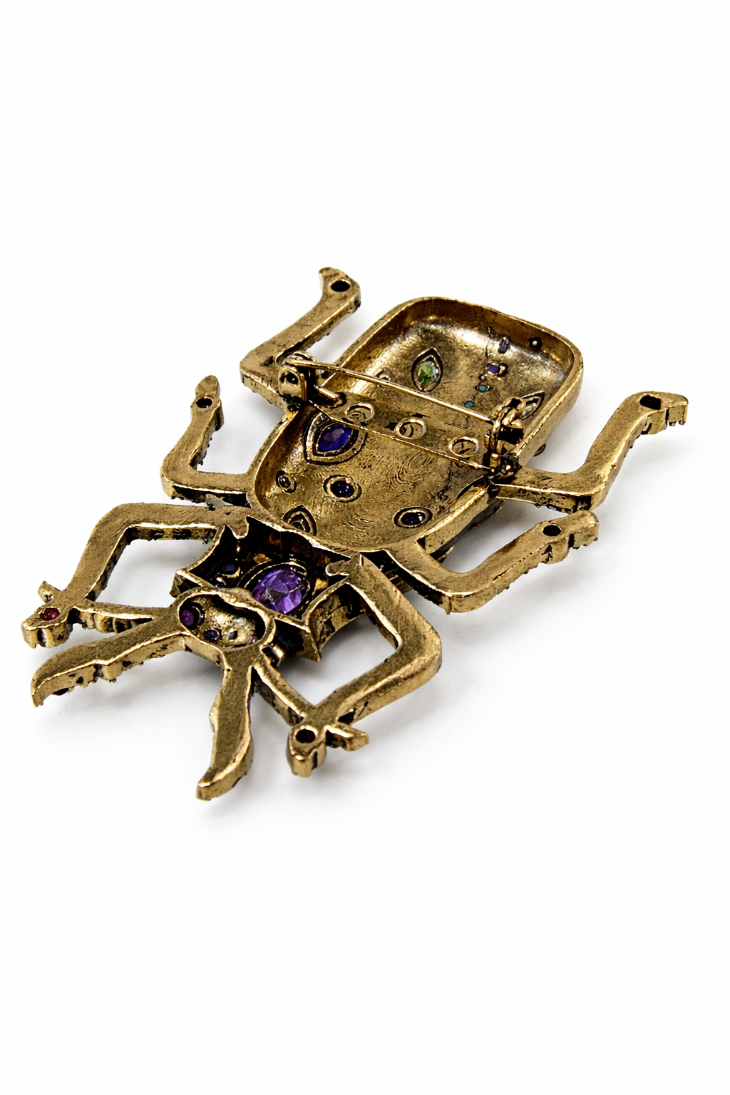 Near Earth Object | Gold spider-shaped brooch with gemstones on a white background