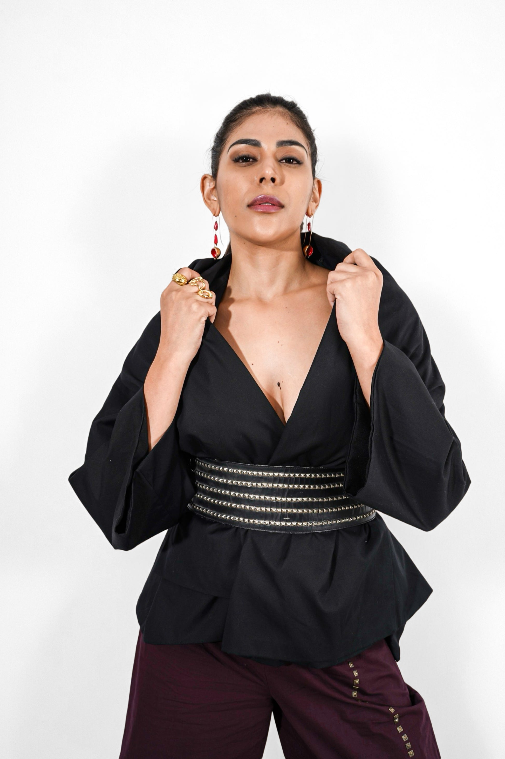 Woman wearing a black wrap top with a deep neckline and coca cola pants | Women's Overlay & Camisole | Jacket | Pret Clothes | nEo Clothes.