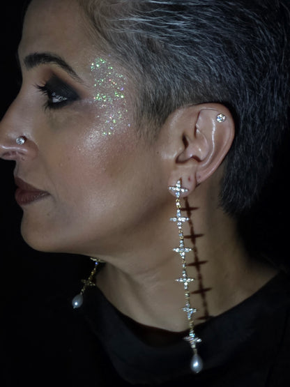 Near Earth Object | Close-up of a person wearing a decorative earring with small stones.