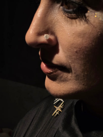 Near Earth Object | Close-up of a person wearing a gold earring with a dark background