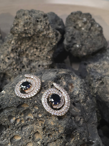Near Earth Object | Pair of silver earrings with gemstones on a textured stone surface