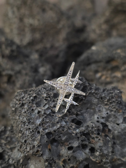 Near Earth Object | Star-shaped silver ring with gemstones on a textured stone surface