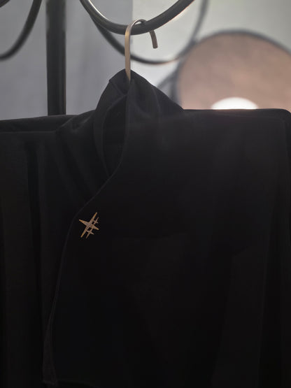 Near Earth Object | Black jacket with a gold emblem on a blurred background
