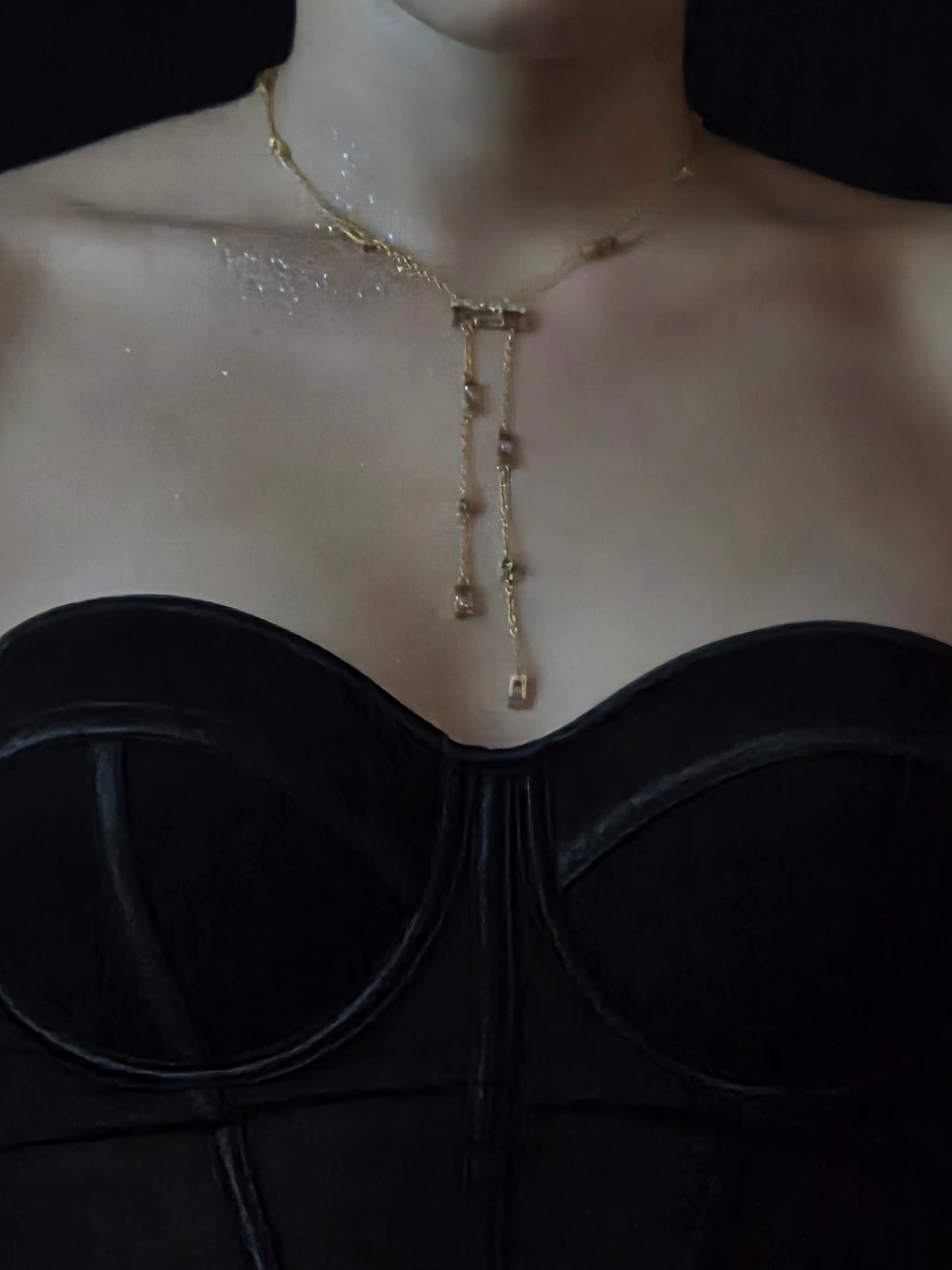 Near Earth Object | necklace on a person's neck with a dark background