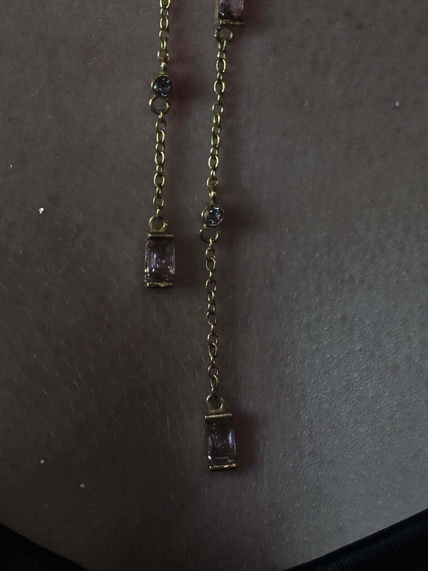 Near Earth Object | Gold bracelet with purple gemstones on a dark surface