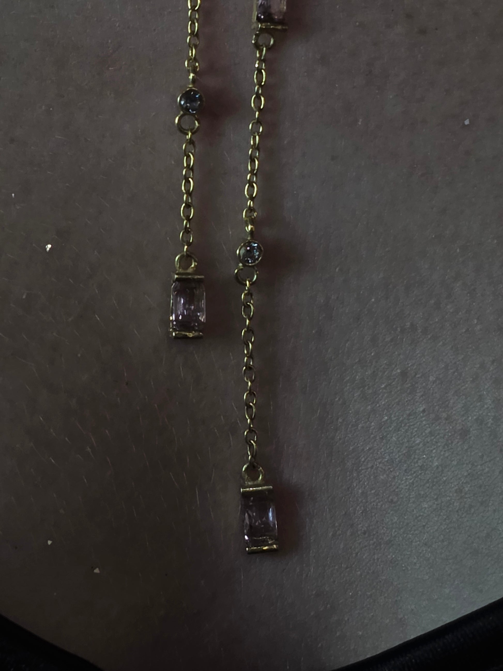 Near Earth Object | Gold bracelet with purple gemstones on a dark surface