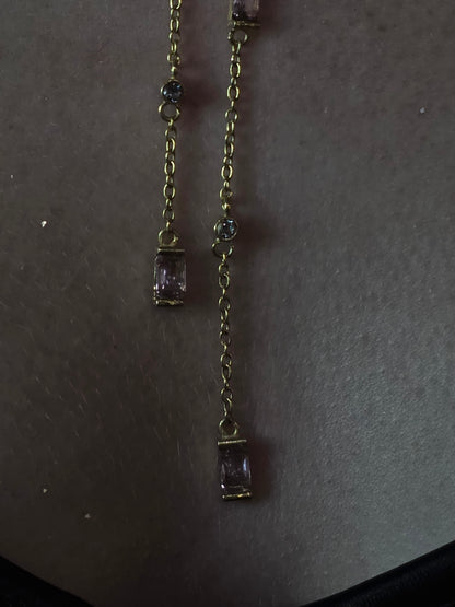 Near Earth Object | Gold bracelet with purple gemstones on a dark surface