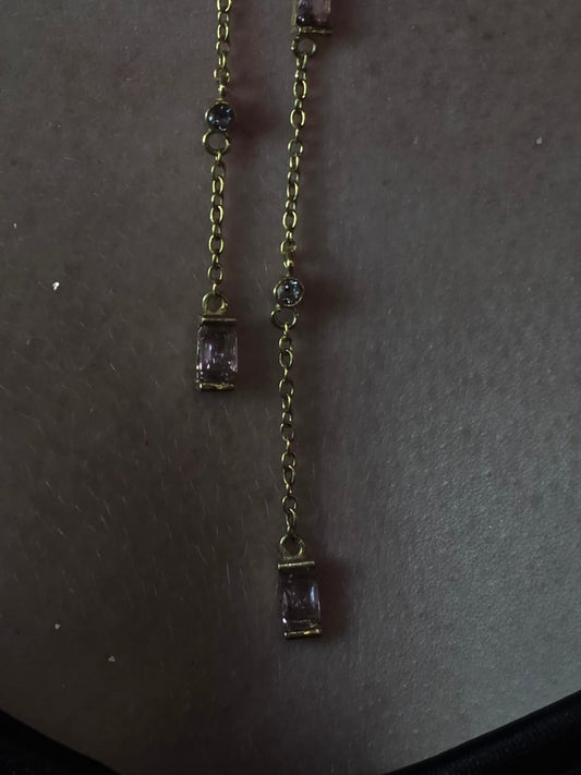 Near Earth Object | Gold bracelet with purple gemstones on a dark surface