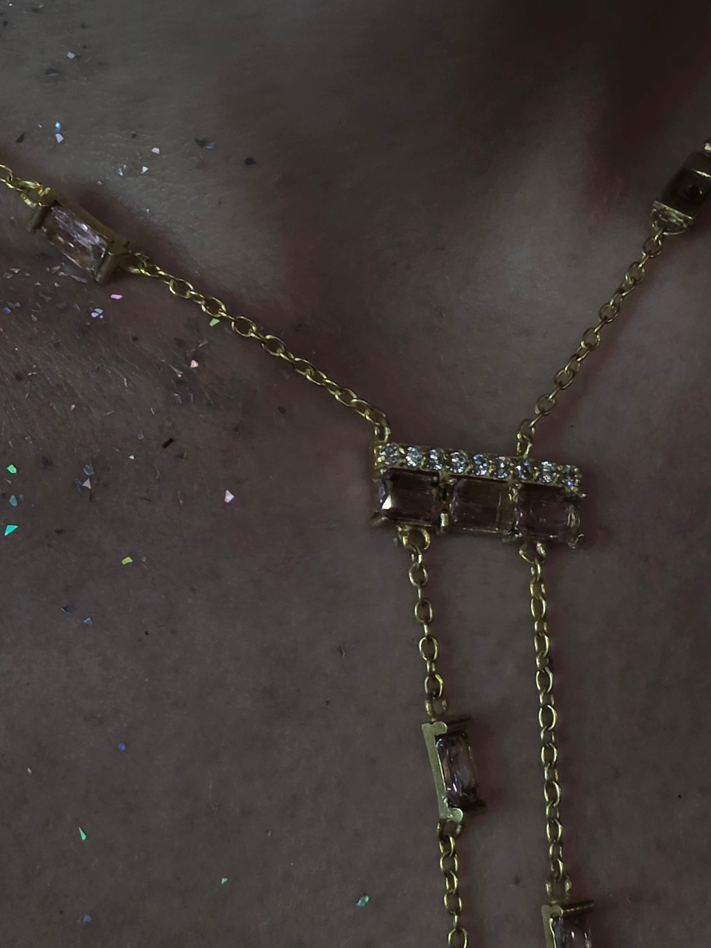 Near Earth Object | Gold necklace with gemstones on a dark surface