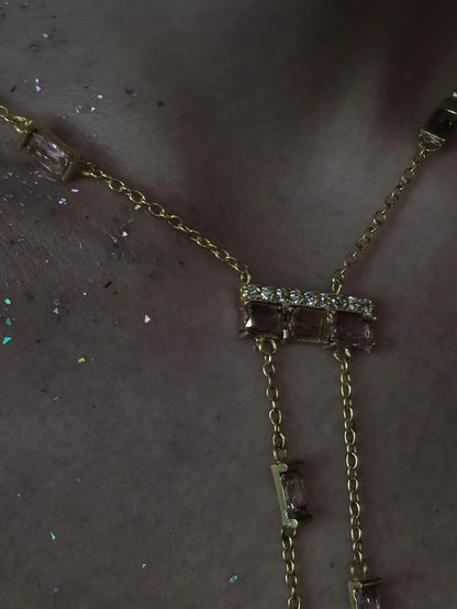 Near Earth Object | Gold necklace with gemstones on a dark surface