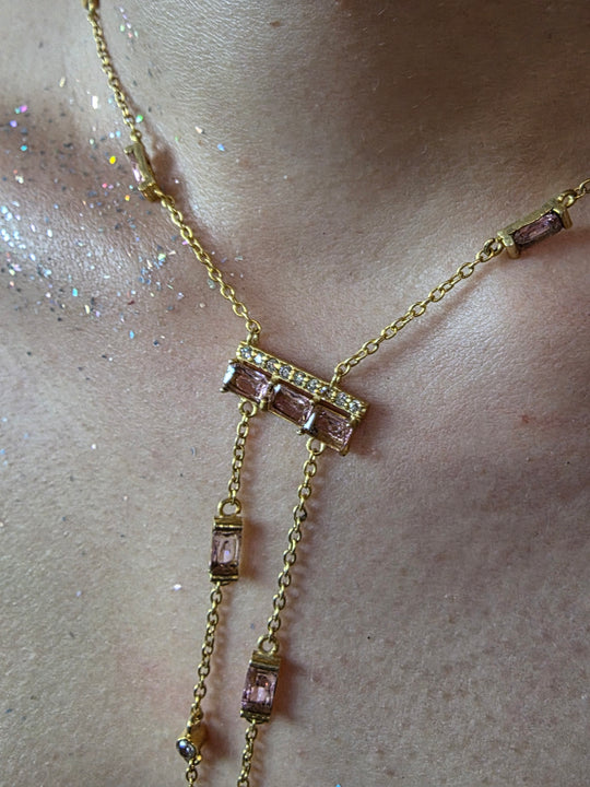 Near Earth Object | Gold anklet with pink gemstones on a light skin background