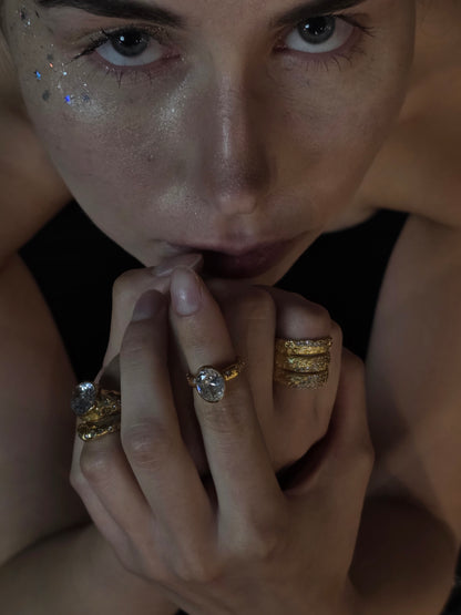 Near Earth Object | Close-up of a person wearing multiple gold rings with gemstones.