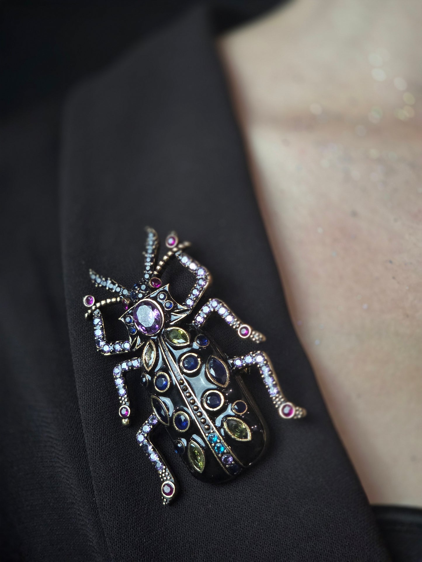Near Earth Object | Decorative brooch shaped like a beetle with gemstones on a dark background