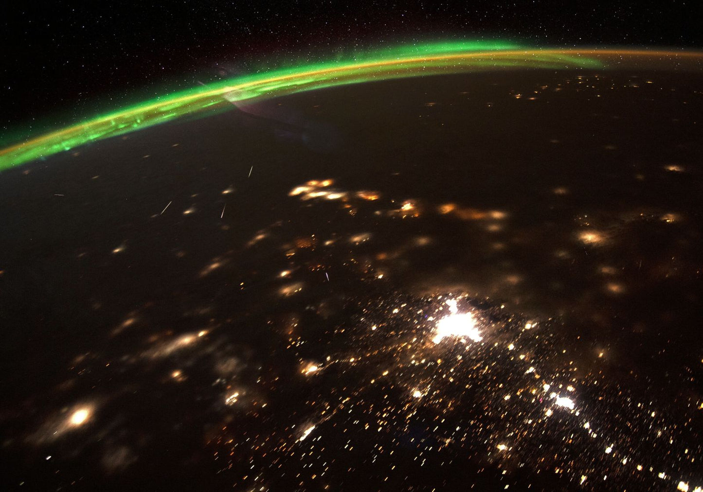A view of Earth from space with a green aurora borealis and city lights. | Statement Earring | neo jewelry