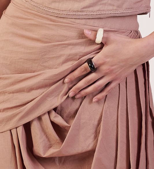 Close-up of a person wearing two rings on a beige Beige  Orbit Cascade Co-Ord Set Dress fabric pant | Women Co-ord Set | Pret Clothes | nEo Clothes.