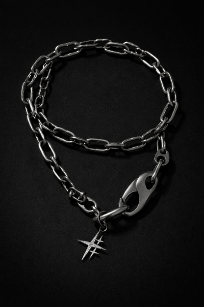 Near Earth Object | Silver chain bracelet with a unique clasp on a black background