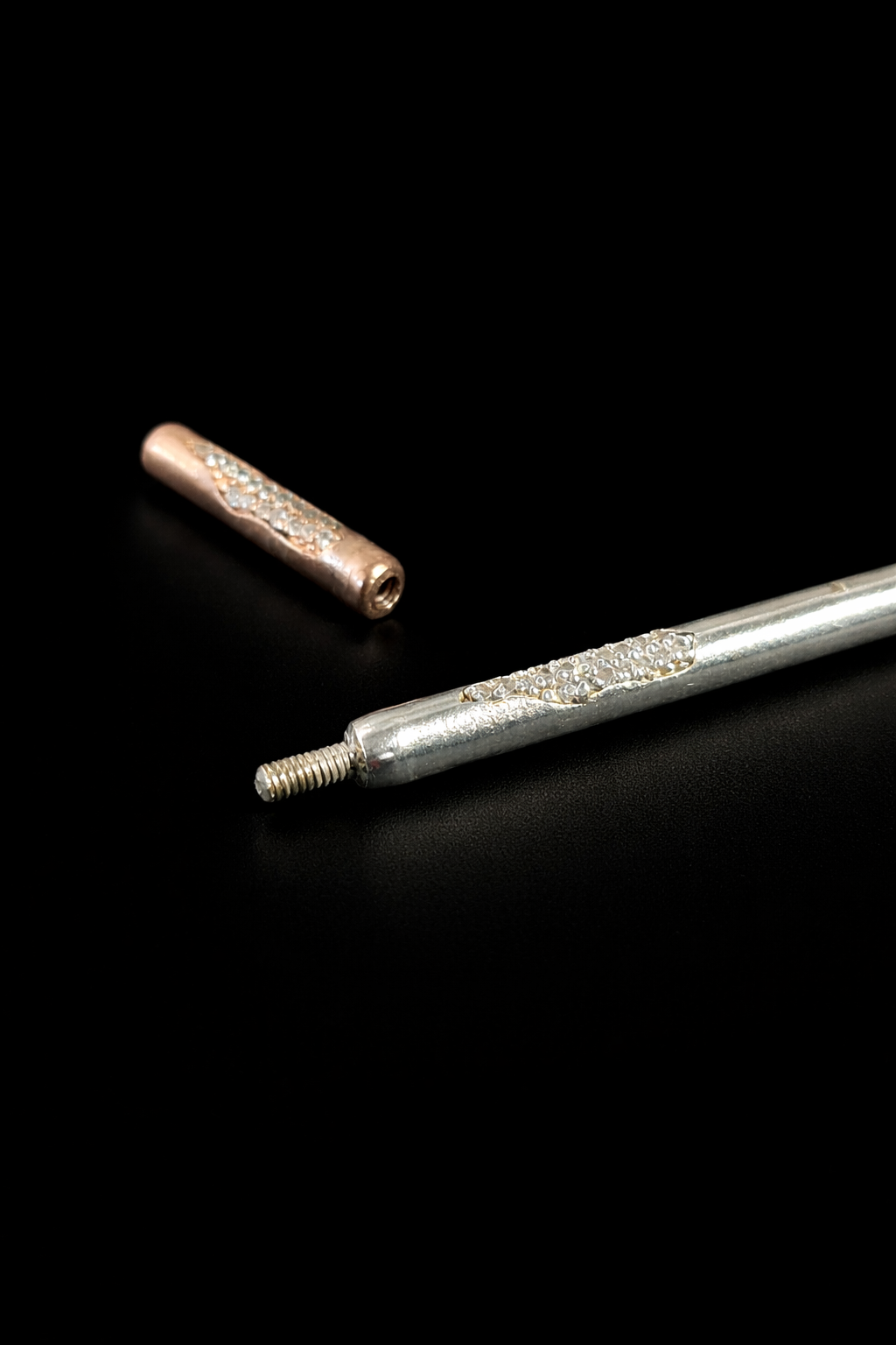 Near Earth Object | Two metal cylindrical objects on a black background