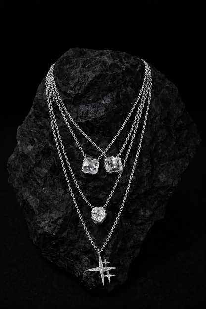 Near Earth Object | Three silver necklaces with gemstones on a textured black surface