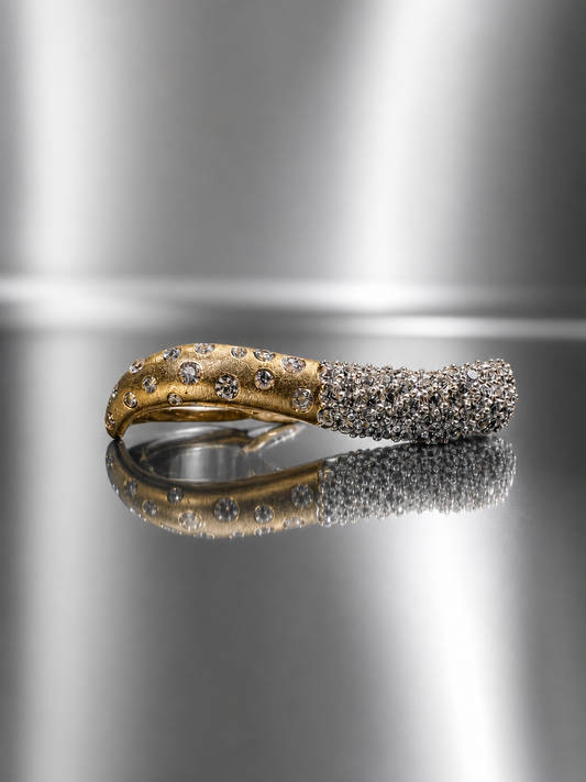 Near Earth Object | Gold and silver ring with embedded stones on a reflective metallic surface