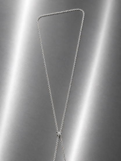 Near Earth Object | Silver chain necklace on a reflective gray surface