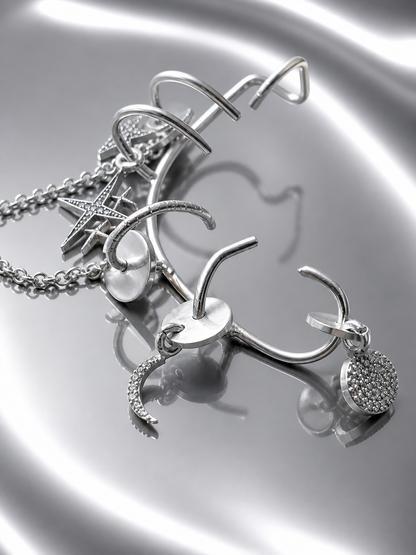 Near Earth Object | Silver jewelry set with charms on a reflective surface