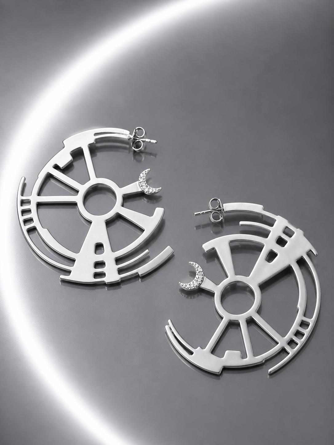 Near Earth Object | Silver earrings with geometric design on a reflective surface