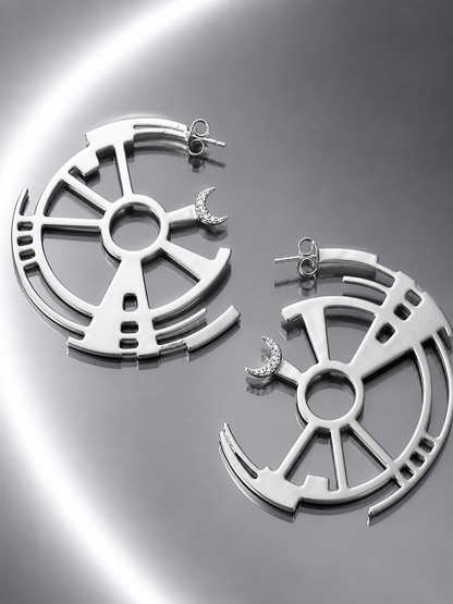 Near Earth Object | Pair of silver earrings on a reflective surface