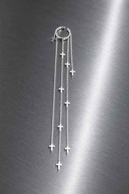 Silver cross necklace on a metallic surface