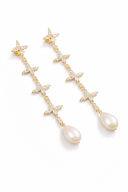 Near Earth Object | Pair of gold earrings with star and teardrop designs on a white background