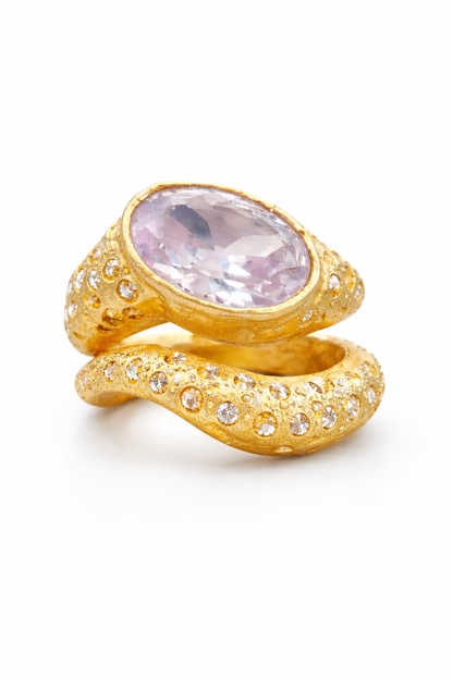 Near Earth Object | Gold snake-shaped ring with a pink gemstone on a white background
