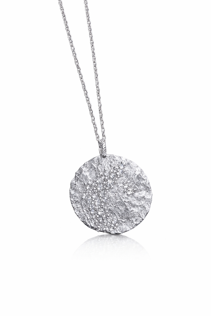 Near Earth Object | Silver necklace with a textured pendant on a white background