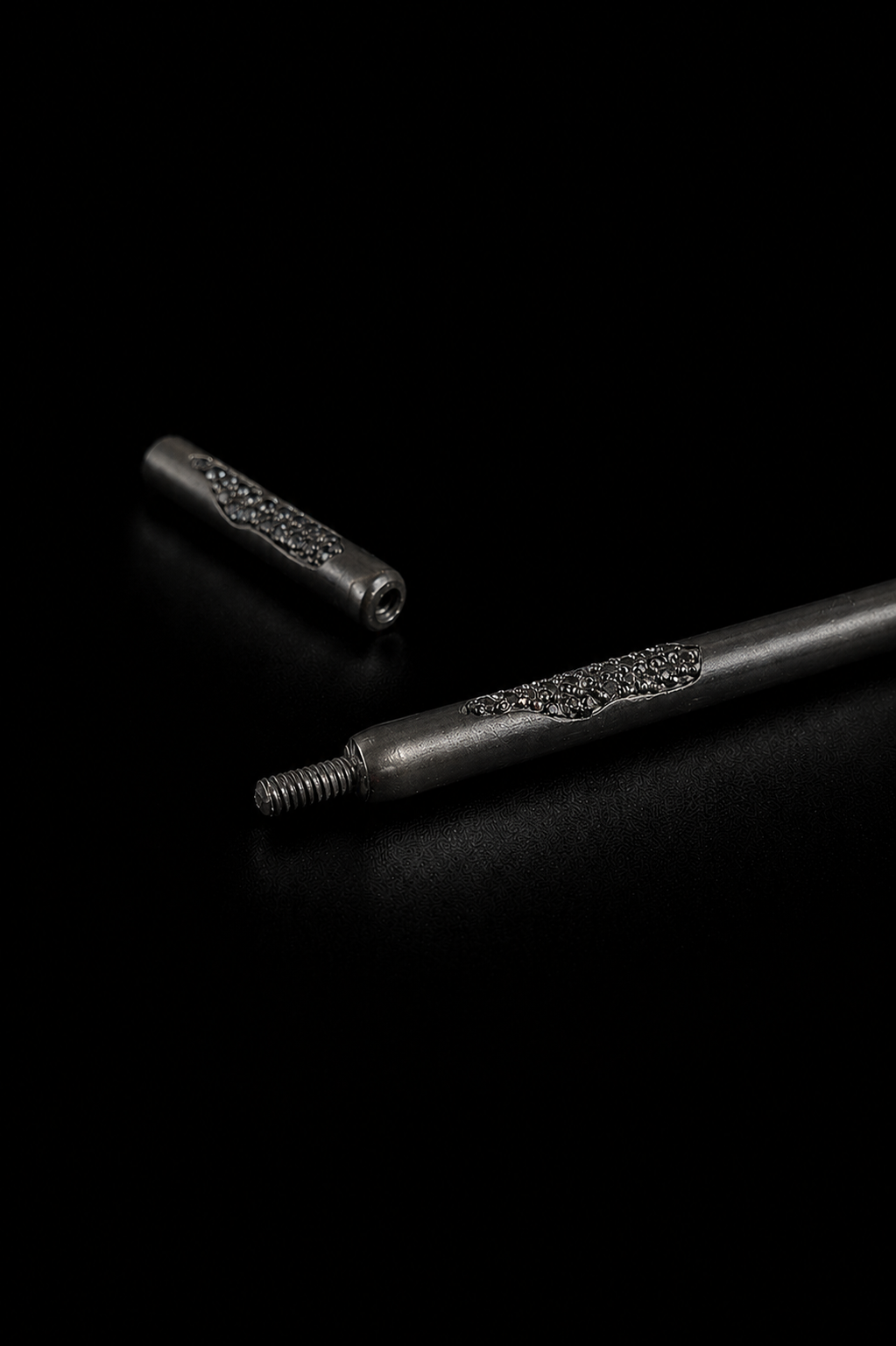 Near Earth Object | Two metallic objects with textured surfaces on a black background