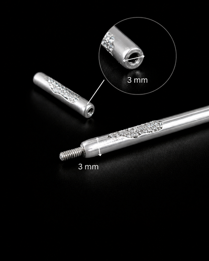 Near Earth Object | Silver cylindrical object with decorative elements on a black background