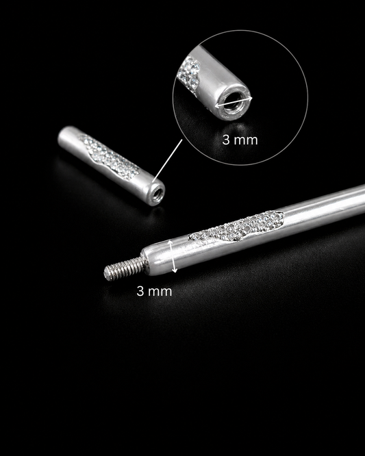 Near Earth Object | Silver cylindrical object with decorative elements on a black background