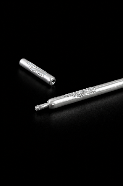 Near Earth Object | Two silver cylindrical objects with decorative elements on a black background