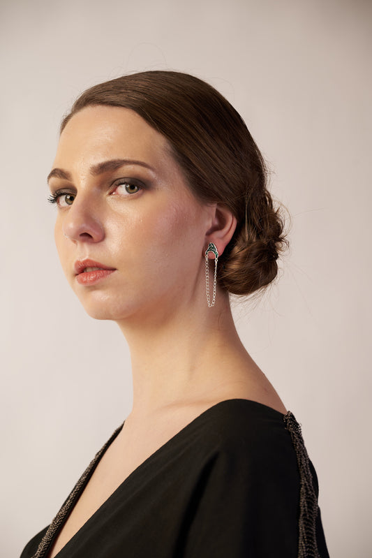 Model wearing green enamel ear studs with silver chain – modern sculptural jewellery by Near Earth Object.