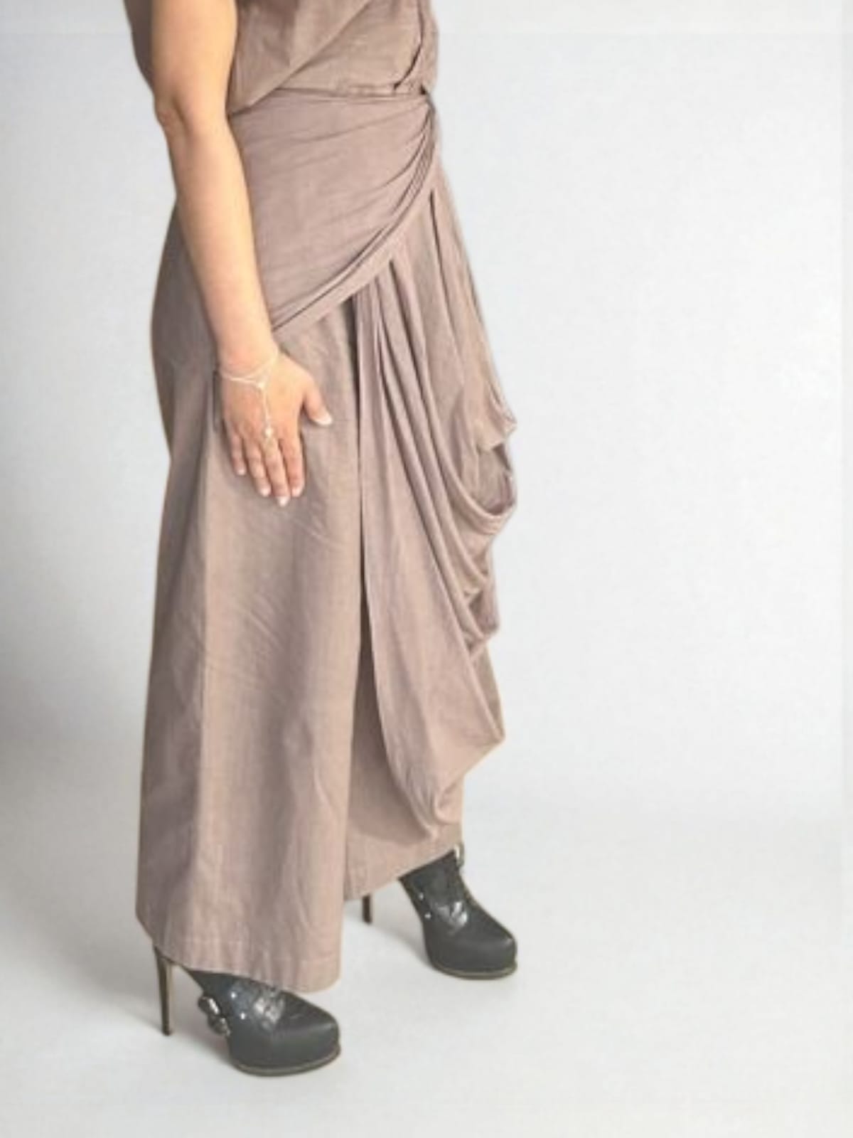 Crater Drape pant Close-up side view of a woman wearing a taupe draped Pant with pleated detailing at the waist and cascading fabric drape, styled with black high-heel ankle boots and minimal silver jewelry, elegant taupe Gray Beige Pant with cascading side drape - near Earth object | Women's Pant | Pret Clothes | Asymmetrical  Pant | nEo Clothes 