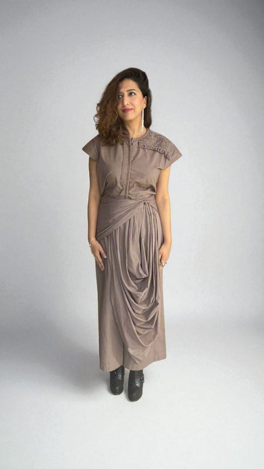 Crater Matter Top : A woman wearing a taupe draped Top with cap sleeves and intricate shoulder detail, styled with gathered pleats at the waist and a cascading draped Pant. She pairs the outfit with black ankle boots, minimal jewelry. women’s contemporary drape  Top for evening wear - near Earth object | Women's  Top | Pret Clothes | Asymmetrical Top | nEo Clothes 