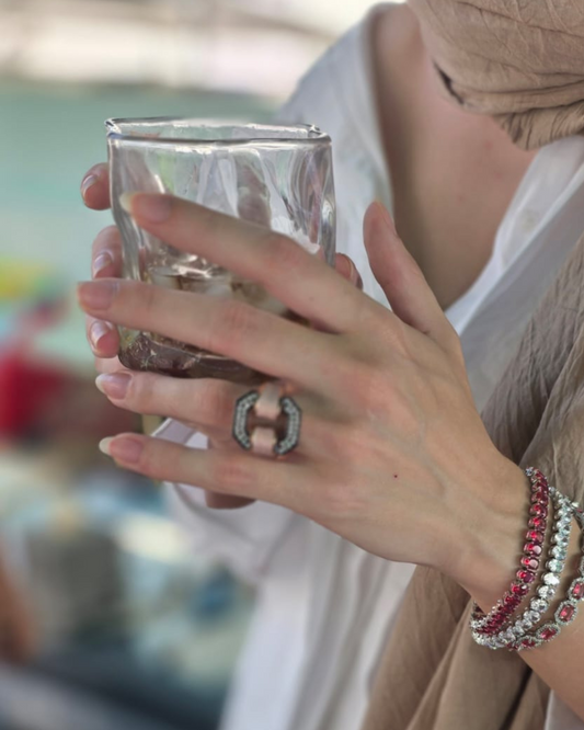 Model wearing mint enamel statement ring styled with layered bracelets for a luxe contemporary look”
