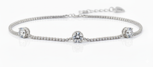 Silver bracelet with three round diamond-style centerpiece stones on a sleek minimal chain.