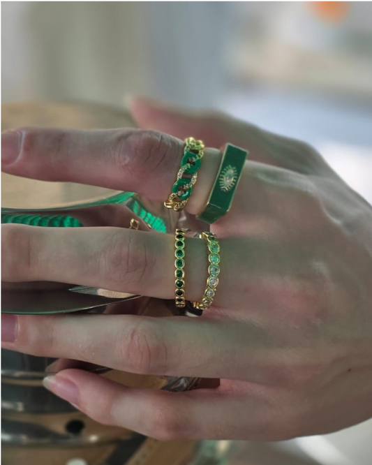 Model wearing stacked gold and emerald rings for a bold luxury jewellery look by Near Earth Object”