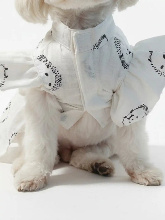 Small dog wearing a white outfit with black patterns 