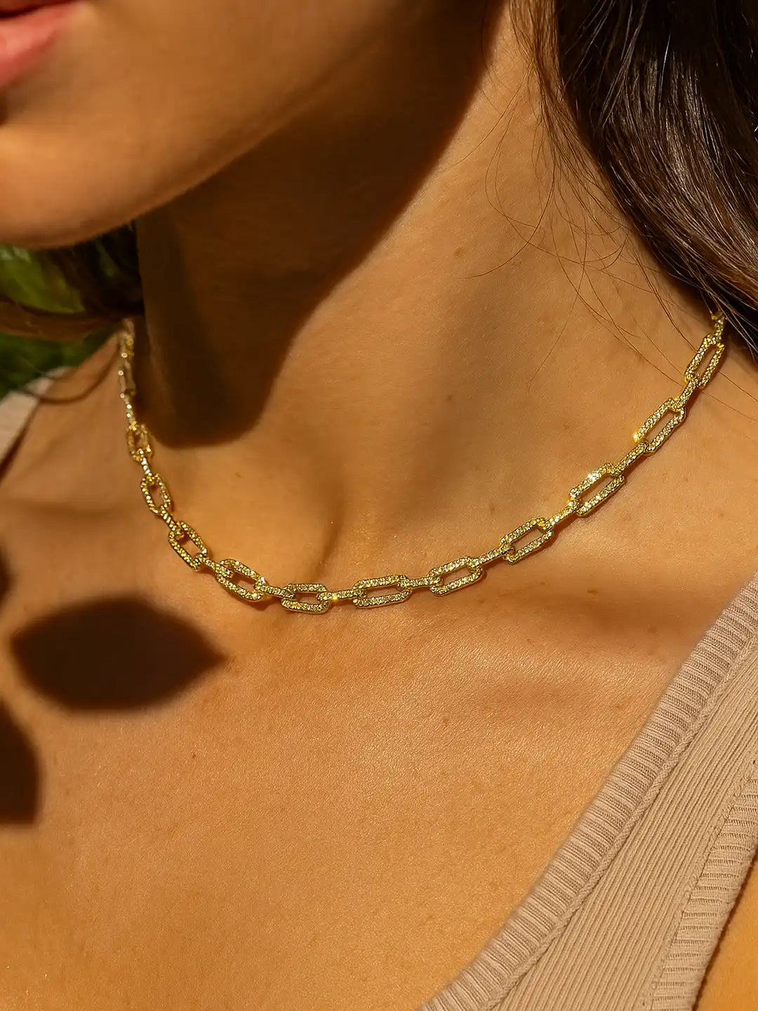 Gold chain choker on a person's neck 