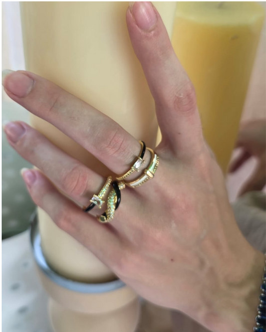 Model wearing stack of gold and black enamel rings on fingers – modern statement ring styling by Near Earth Object.