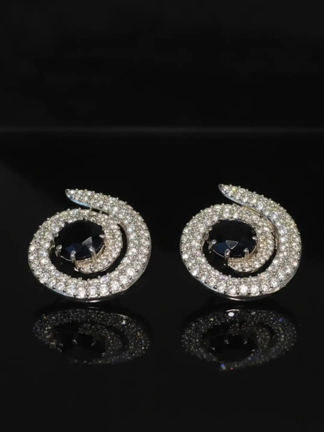 Near Earth Object | Pair of spiral earrings with gemstones on a black background