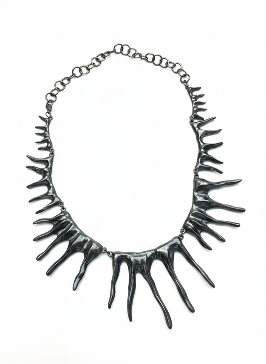 Black sculptural spike necklace with organic molten texture – avant-garde statement jewellery by Near Earth Object.