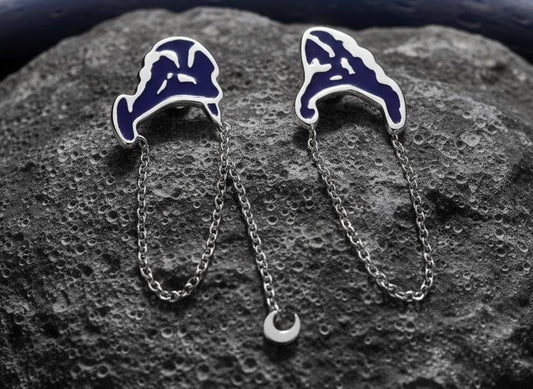 Blue enamel wave ear cuffs with silver chain drop, styled on lunar rock surface – cosmic jewellery concept by Near Earth Object.