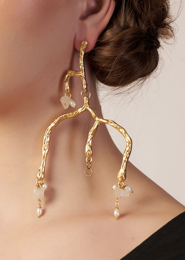 Gold earrings with pearl drops worn by a person | Statement Earring | neo jewelry
